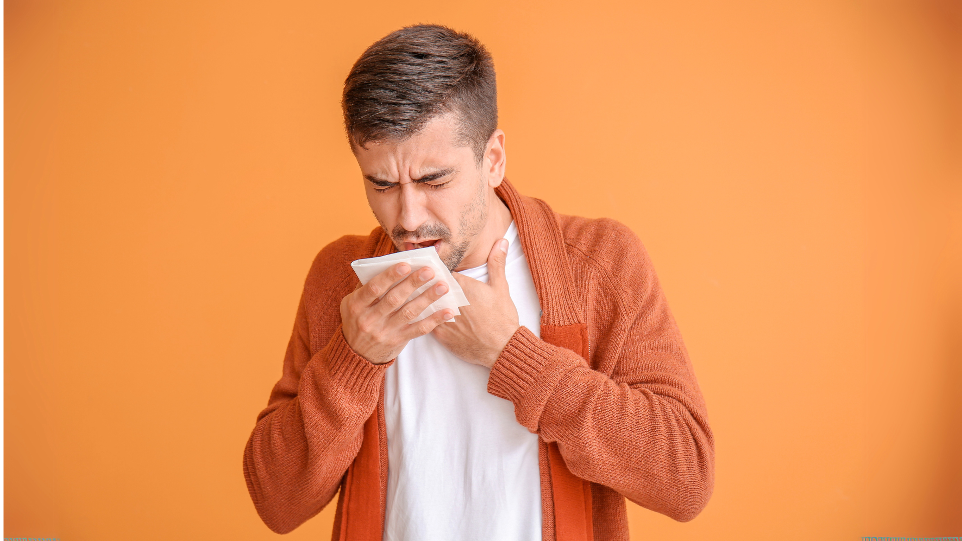 Concerned man coughing with eyes closed, showing seasonal cough symptoms.