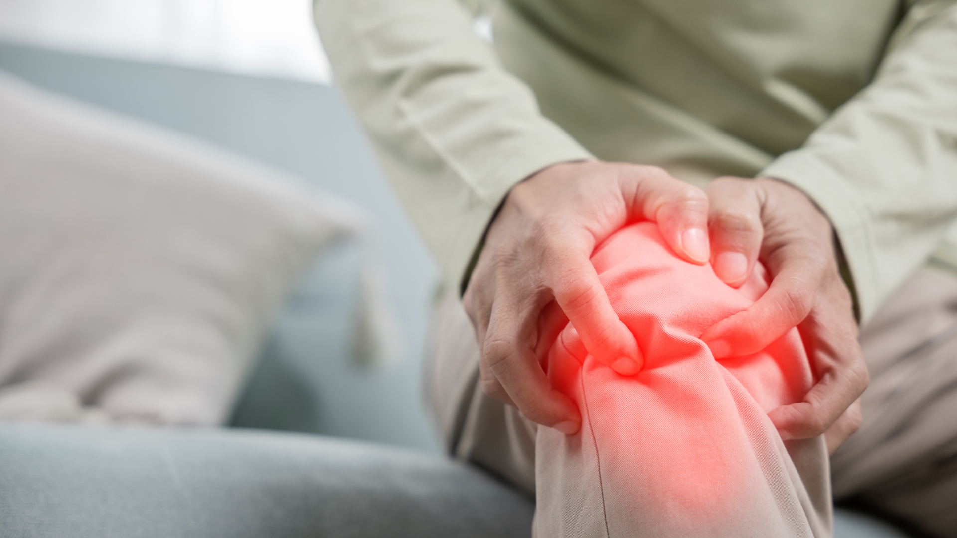  Close-up of a person holding their knee in pain, highlighting joint discomfort in winter